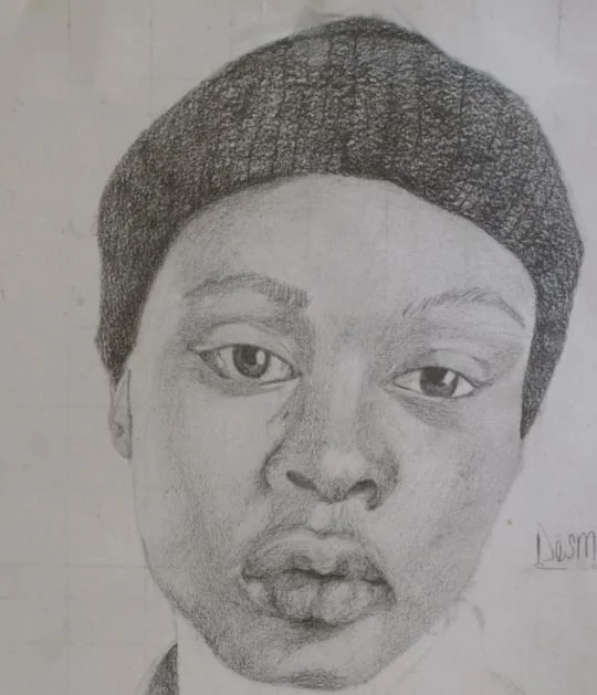 Graphite portrait of a young man in a knit beanie.
